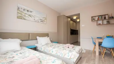 a small bedroom with two beds and a table at Студио Булаир 1 с безплатен паркинг in Burgas City