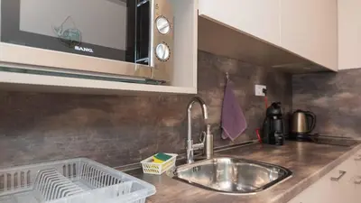 a kitchen counter with a sink and a microwave at Студио Булаир 1 с безплатен паркинг in Burgas City