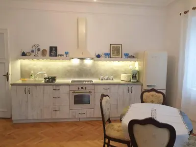 a kitchen with a sink and a refrigerator and a table at Апартамент BOHO CHIC 2 Free parking in Varna City