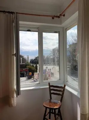 a wooden chair sitting in front of a window at Апартамент BOHO CHIC 2 Free parking in Varna City