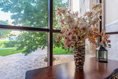 a vase of flowers sitting on a table next to a window at Premium complex Millennium 2 - Family apartment & Spa in Sveti Vlas