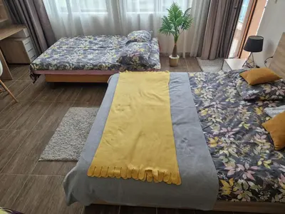 a bedroom with two beds and a yellow blanket at Sun Wave Apartament in Sveti Vlas