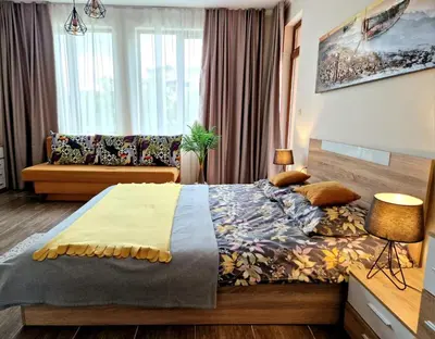 a bedroom with a bed and a couch at Sun Wave Apartament in Sveti Vlas