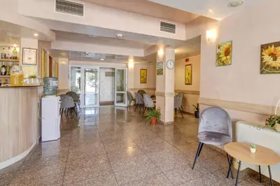 a large room with tables and chairs and a kitchen at Paraiso Beach - All Inclusive in Obzor