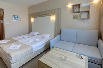 a hotel room with two beds and a couch at Paraiso Beach - All Inclusive in Obzor