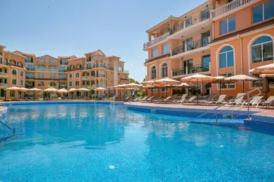 a swimming pool in a hotel with chairs and umbrellas at Touristic Complex Hacienda Beach Apartments Sozopol in Sozopol