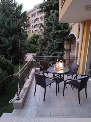 a patio with a table and chairs and a building at Midia Grand Resort, Terrassen Paradies Apartment in Aheloy