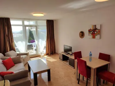 a living room with a couch and a table at Midia Grand Resort, Terrassen Paradies Apartment in Aheloy