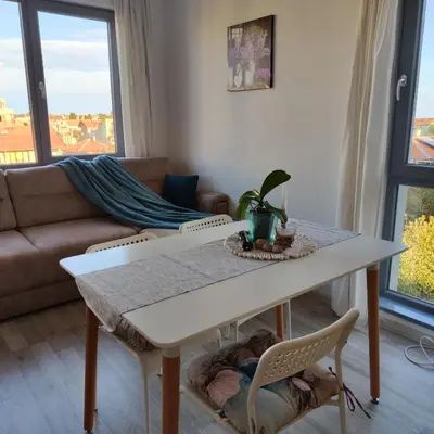 a living room with a table and a couch at апартамент на брега на морето Бургас - Сарафово in Burgas City