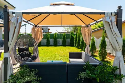 a patio with a swing and an umbrella at La Mansión in Lozenets