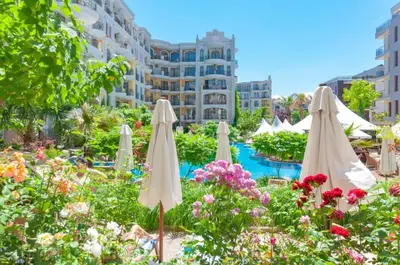 a group of white umbrellas in a garden with flowers at Monte Carlo in Sunny Beach