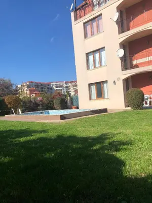 a building with a grassy yard in front of a building at Dunav Apt.4 in Ravda