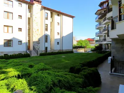 a courtyard of a building with a green lawn at Бяла Виста Бийч Апартментс B - Byala Vista Beach Apartments B in Byala