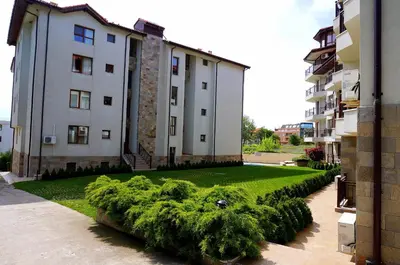 a building with a green hedge in front of a building at Бяла Виста Бийч Апартментс B - Byala Vista Beach Apartments B in Byala
