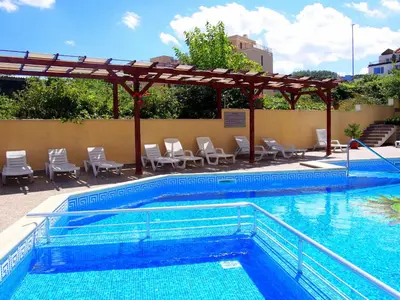 a swimming pool with chairs and a pergola at Бяла Виста Бийч Апартментс B - Byala Vista Beach Apartments B in Byala