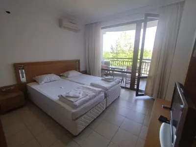 a bedroom with a bed and a balcony at СПА Апартаменти за ГОСТИ Затворен комплекс ЕМЕРАЛД in Ravda