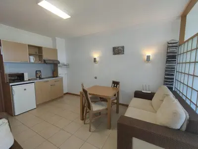 a living room with a couch and a table at СПА Апартаменти за ГОСТИ Затворен комплекс ЕМЕРАЛД in Ravda