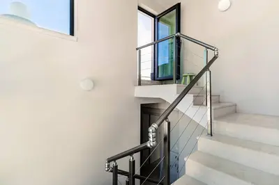 a staircase in a house with a window at ЛУКСОЗНА ТРИЕТАЖНА КЪЩА в центъра на Приморско in Primorsko