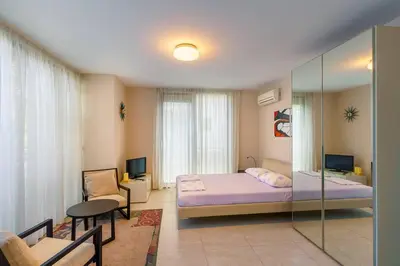 a bedroom with a bed and a glass wall at ЛУКСОЗНА ТРИЕТАЖНА КЪЩА в центъра на Приморско in Primorsko
