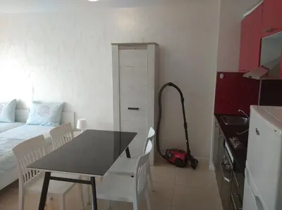 a kitchen with a table and a bedroom with a bed at Niya Apartments Kavaci Sozopol in Sozopol