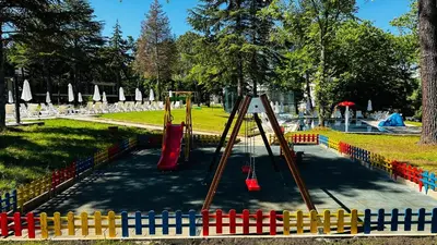 a playground with a slide in a park at Queen Nelly Park in Kiten