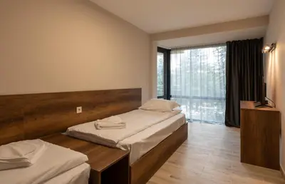 a bedroom with two beds and a large window at Queen Nelly Park in Kiten