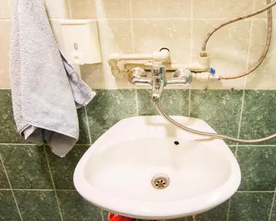 a white sink in a green tiled bathroom at DOWNTOWN - BEST Price Small Apartment in Burgas City