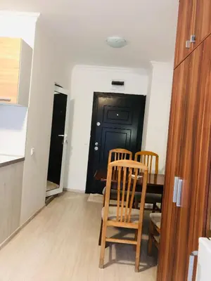 a kitchen with a table and two chairs and a black door at Apartments Sarafovo in Burgas City