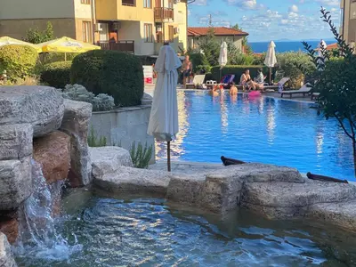 a swimming pool with an umbrella and a fountain at GARDEN OF EDEN B3-2 Private One Bedroom Apartment in Sveti Vlas