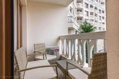 a balcony with chairs and a building at Stoyanov South Bay - Varna in Varna City