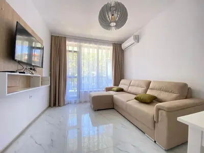 a living room with a couch and a television at The Green Paradise Apartments in Primorsko