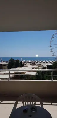 a balcony with a chair and a ferris wheel at Excelsior Holiday Apartments 91 Sunny Beach Bulgarien Sonnenstrand in Sunny Beach