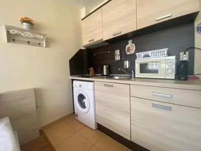 a kitchen with a washing machine and a microwave at SUMMER BREEZE 406 Studio Sunny Beach in Sunny Beach