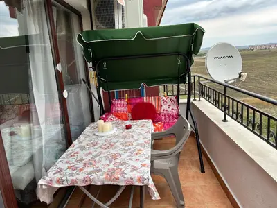 a table and chairs sitting on a balcony at Аpartments Comfort -Marina Cape in Aheloy