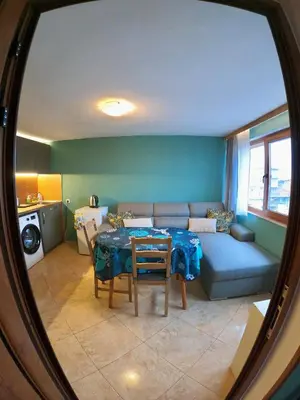 a living room with a table and a couch at Sunset Yavorov Pomorie in Pomorie