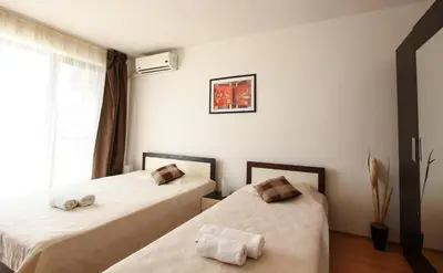 two beds in a room with a window at Seaside Apartment with 2 Bedrooms for up to 5 Guests in Sunny Beach
