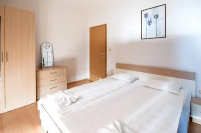 a bedroom with a large white bed and a cabinet at Seaside Apartment with 2 Bedrooms for up to 5 Guests in Sunny Beach