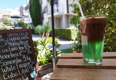 a drink in a glass sitting on a wooden table at Seaside Apartment with 2 Bedrooms for up to 5 Guests in Sunny Beach