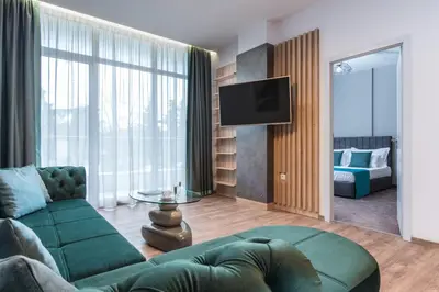 a living room with a green couch and a television at Green Luxury Apartments in Burgas City