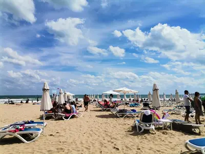 a group of people sitting on the beach at Lovely Apartments Amadeus Lux in Sunny Beach