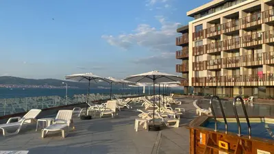 a group of chairs and umbrellas next to a building at PARADISO B 210 Private Sea View Studio NESSEBAR in Nesebar