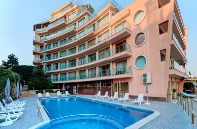a hotel with a swimming pool in front of a building at Beachfront Apartments by Marty's in Sunny Beach