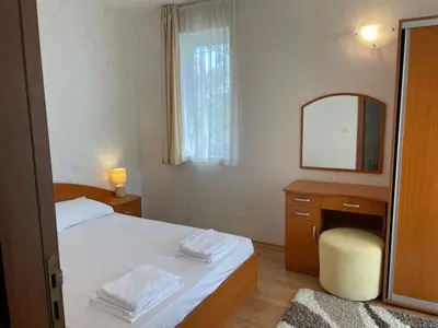 a bedroom with a bed and a vanity with a mirror at Rutland SP apartments in Ravda