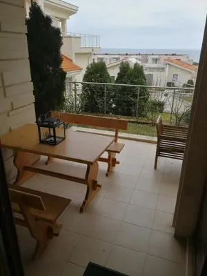 a patio with a table and benches on a balcony at Fantastic family villa with sea view in Byala