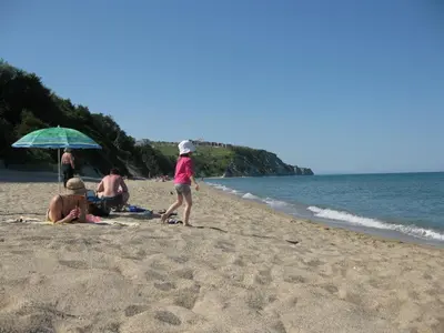 a group of people sitting on the beach at Fantastic family villa with sea view in Byala
