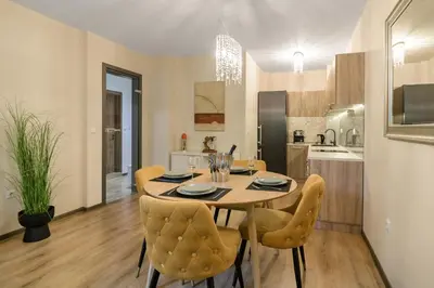 a kitchen and dining room with a table and chairs at МareliS Luxe Port Apartment in Varna City