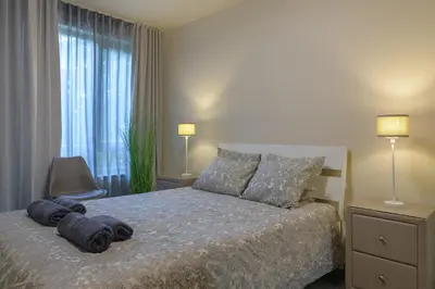 a bedroom with a bed with two pillows on it at МareliS Luxe Port Apartment in Varna City