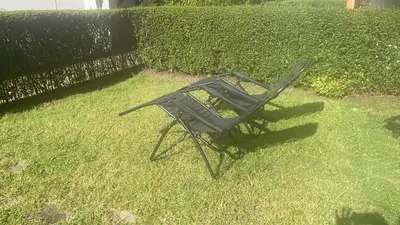 a chair sitting in the grass in a yard at Manastira-2 (A-3) in Sveti Vlas