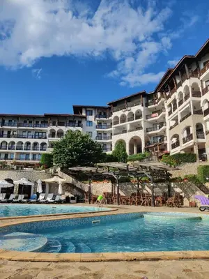 a hotel with a swimming pool in front of a building at Manastira-2 (A-3) in Sveti Vlas