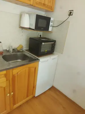 a small kitchen with a microwave and a sink at Studio and 1bedroom apartment Burgas - Economy in Burgas City